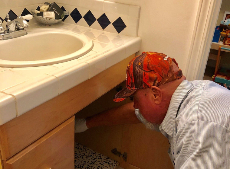 plumber checking bathroom plumbing